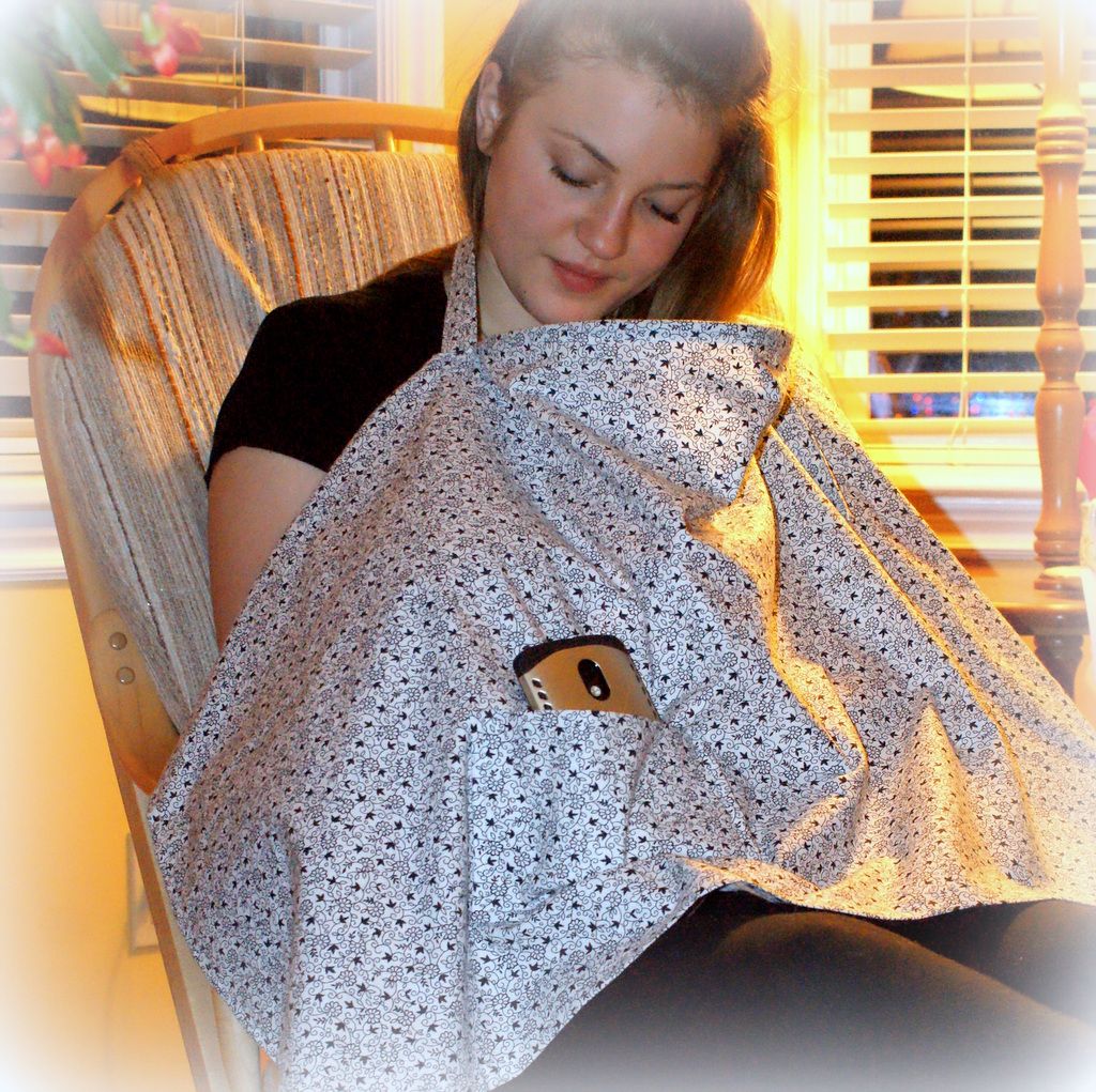 Woman sitting in chair with nursing cover over her chest