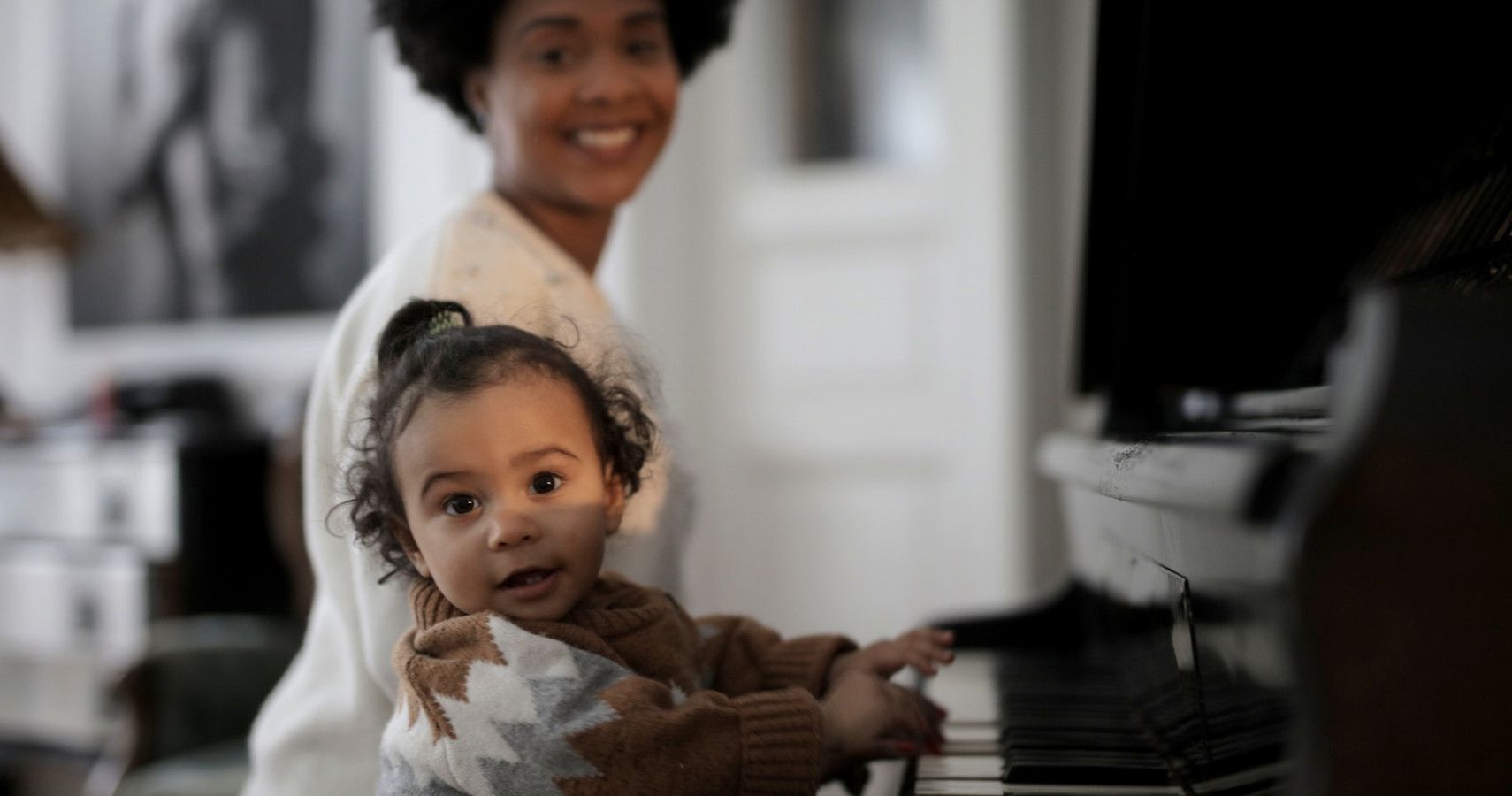 Mom teaching her child to play the piano