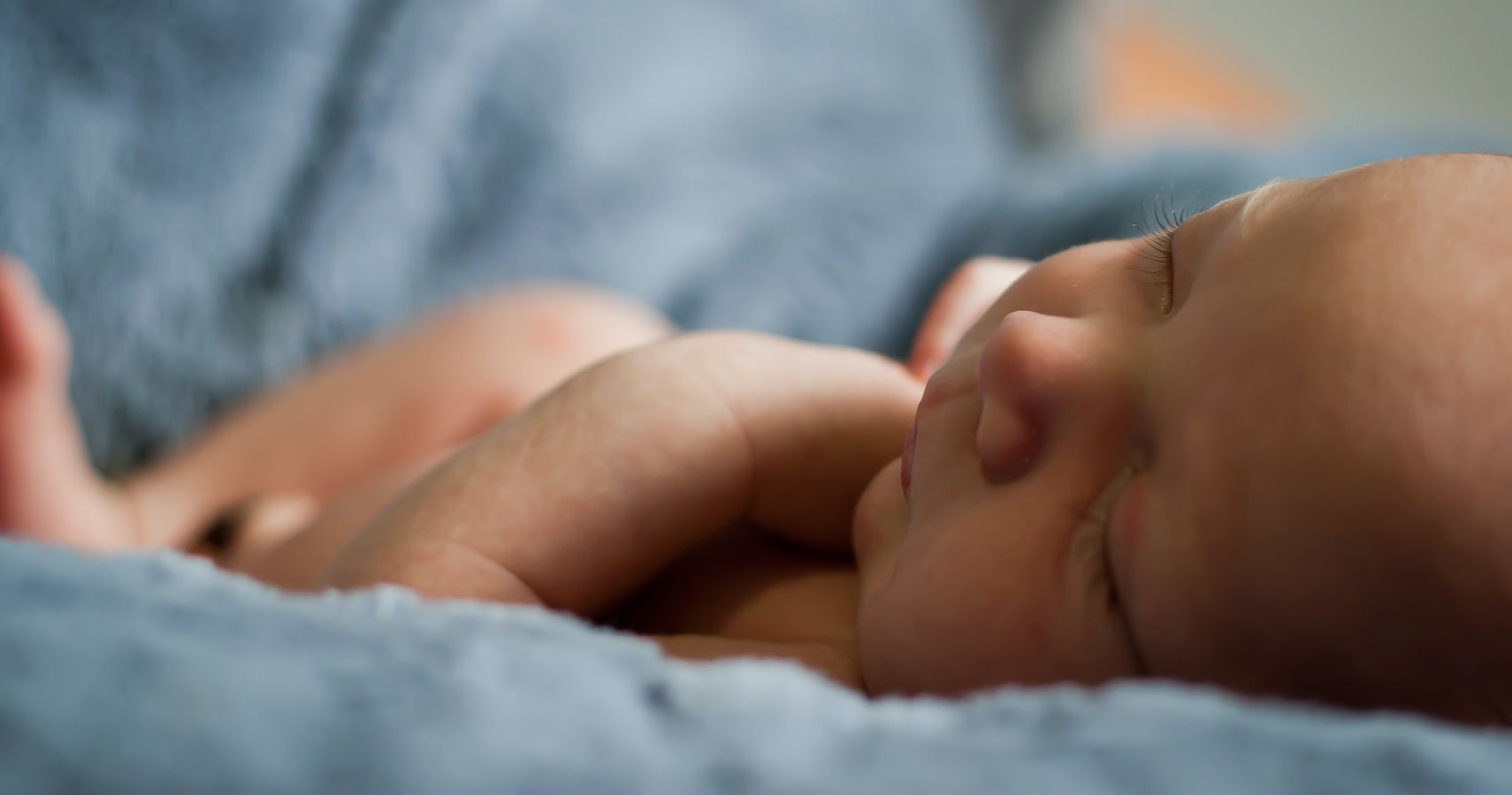 A baby asleep on a blue blanket