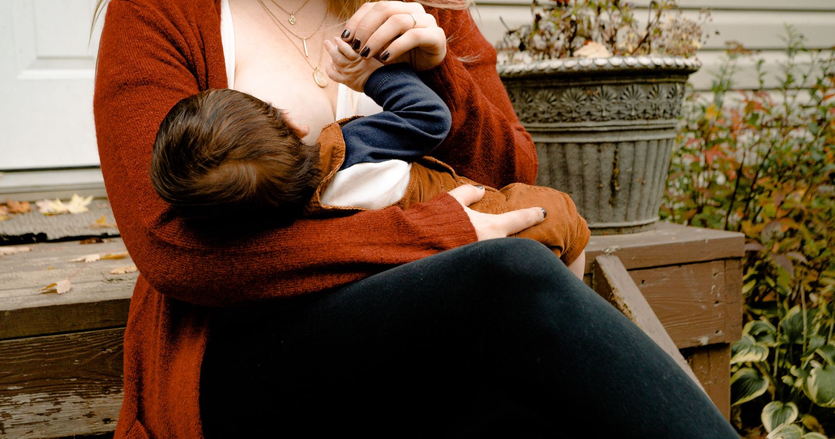 A mom breastfeeding her baby outside