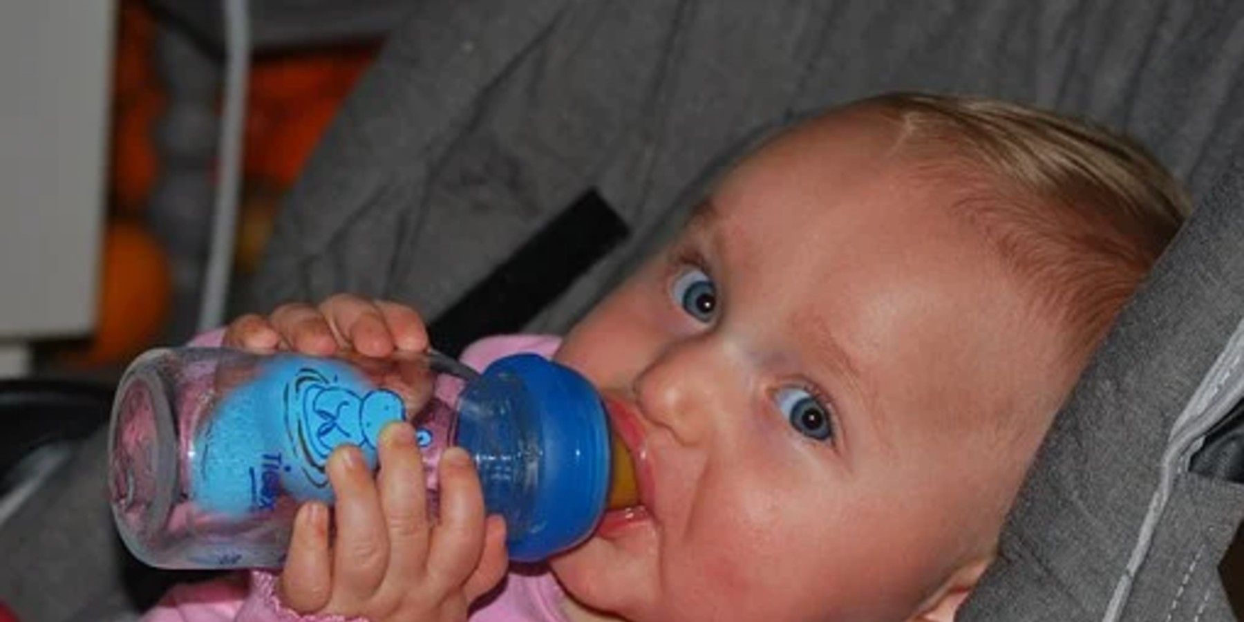 Baby drinking from bottle, and they are not the world's longest breastfed baby.