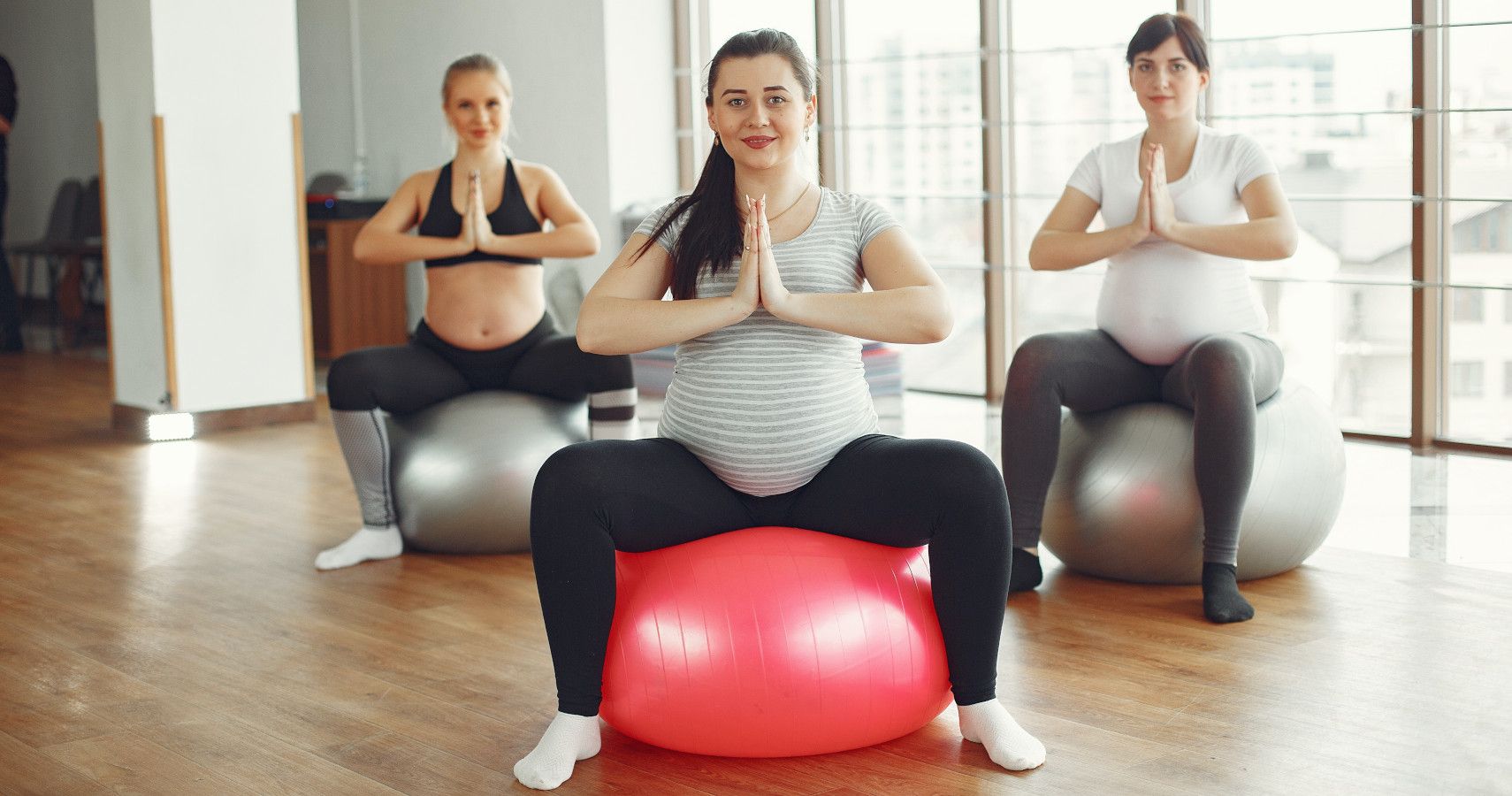 Three pregnant women working out together in the gym.