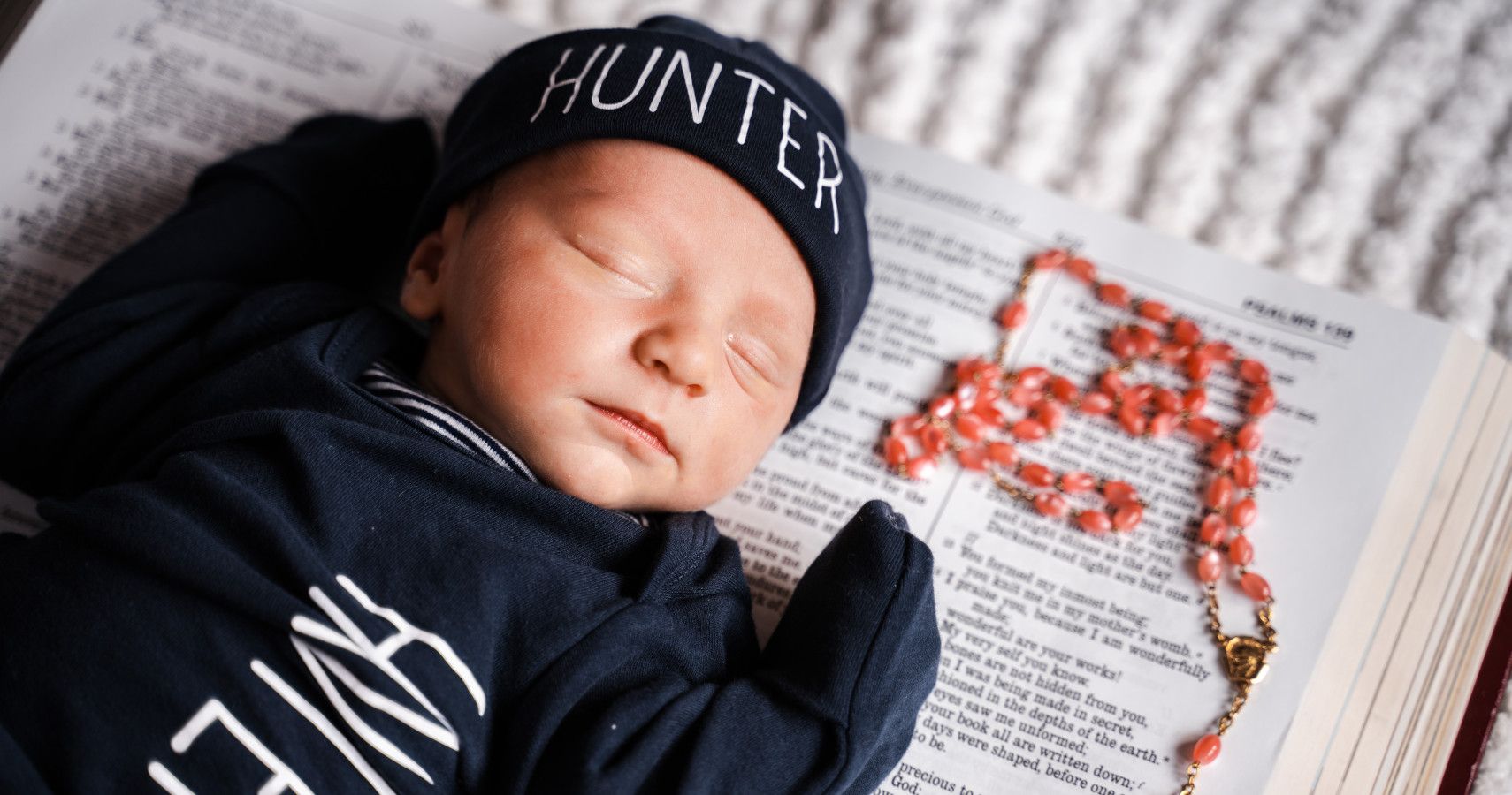 A baby fast asleep on the Bible.