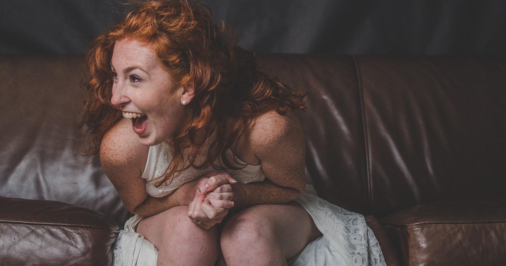 red hair woman couch laughing