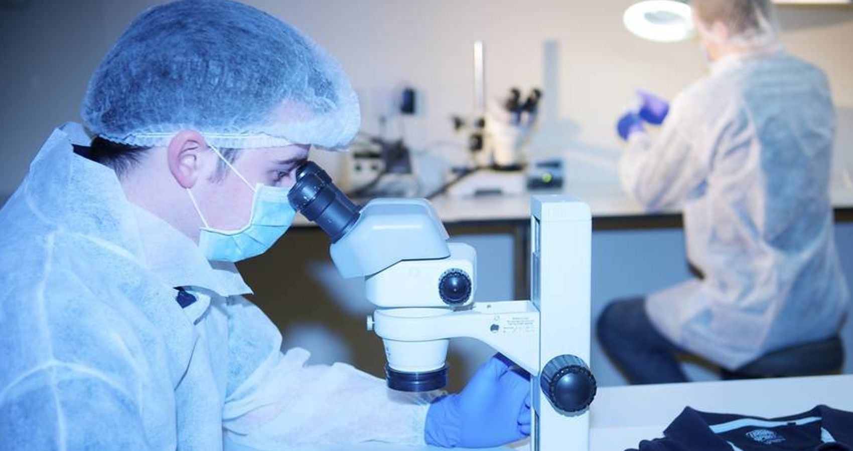 A scientist working with a microscope in a lab