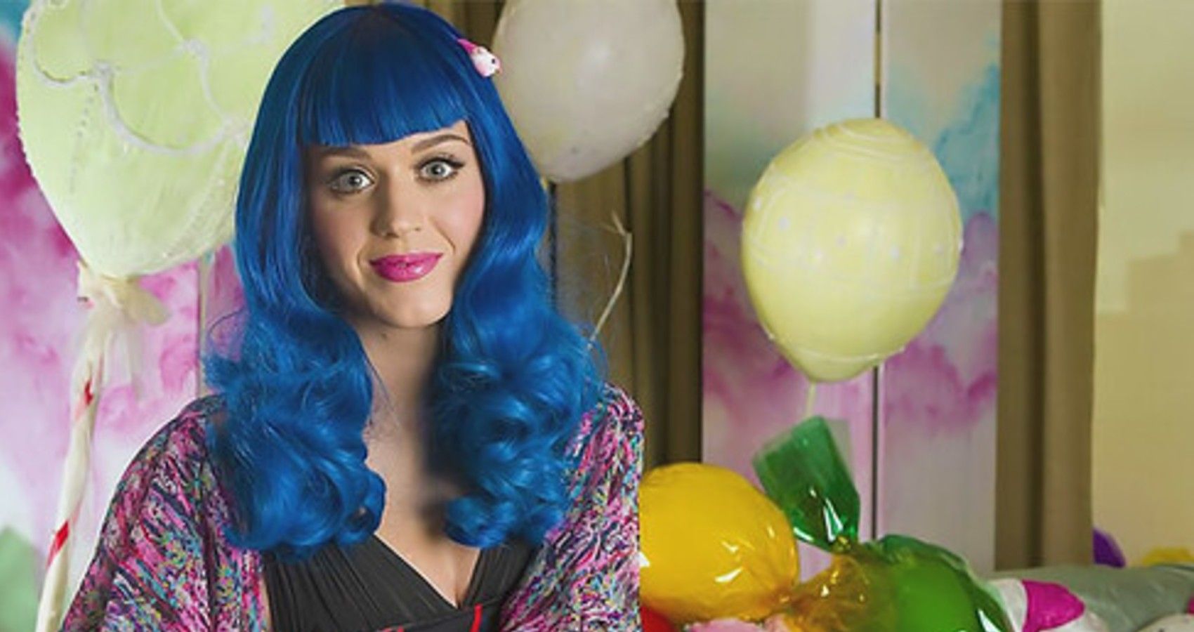 Katy Perry sitting with balloons and blus hair