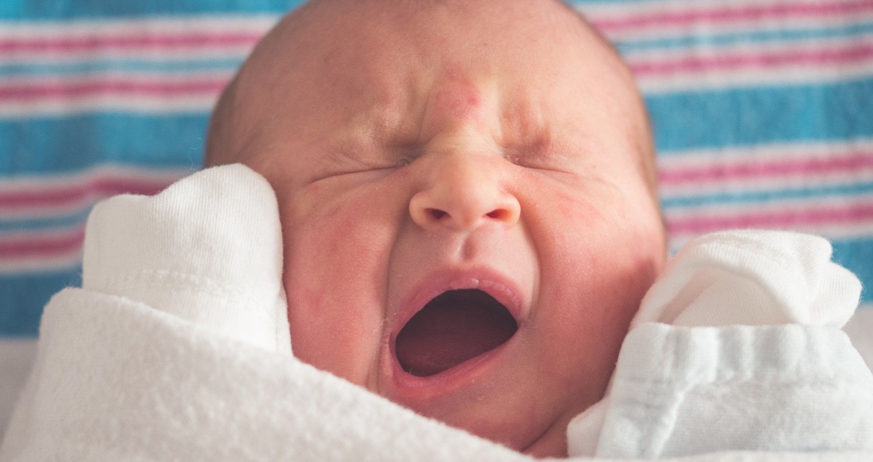 A small newborn baby yawning