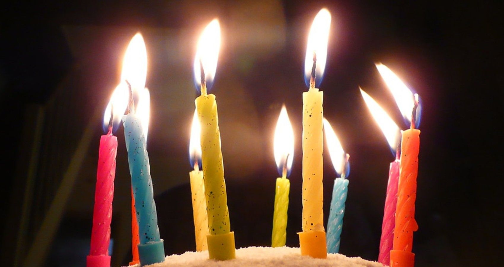a row of lit candles on a birthday cake