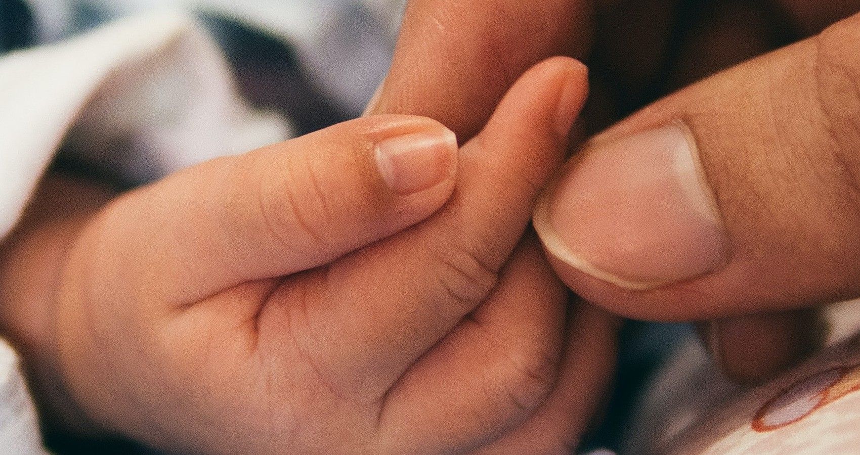 A Parent Holding On To A Baby's Hand