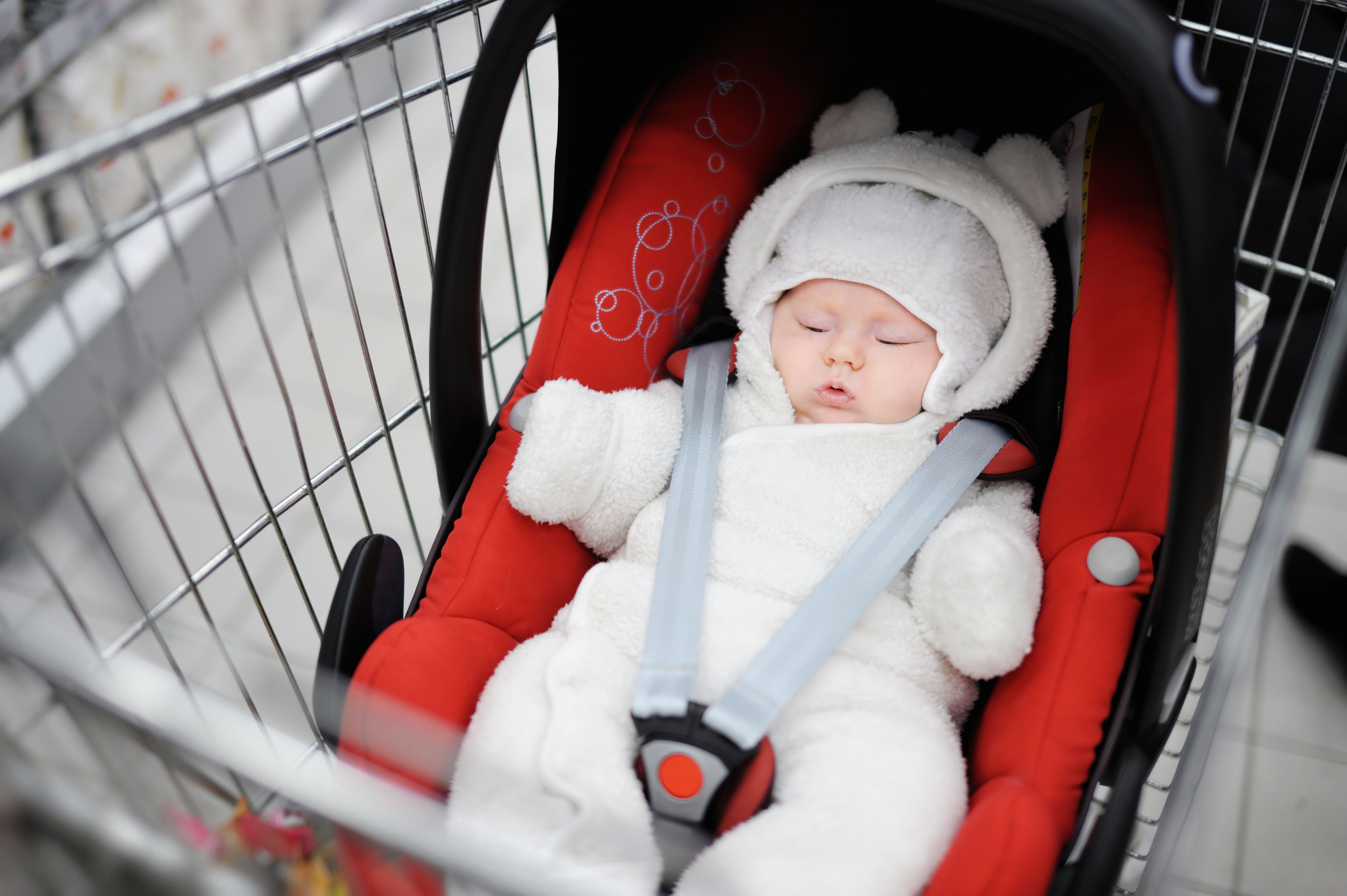 baby in car seat inside shopping cart