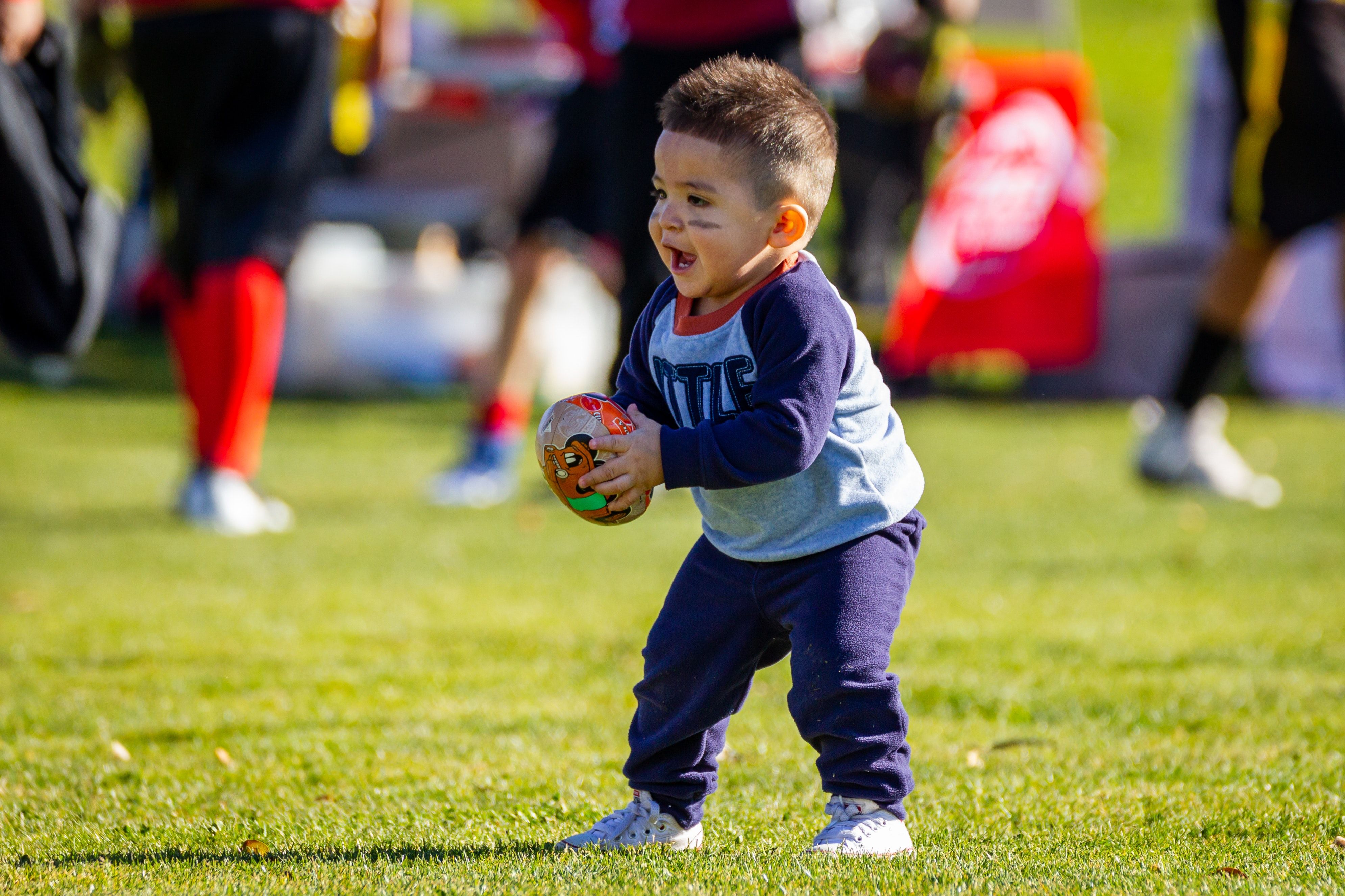 Toddler boy playing football