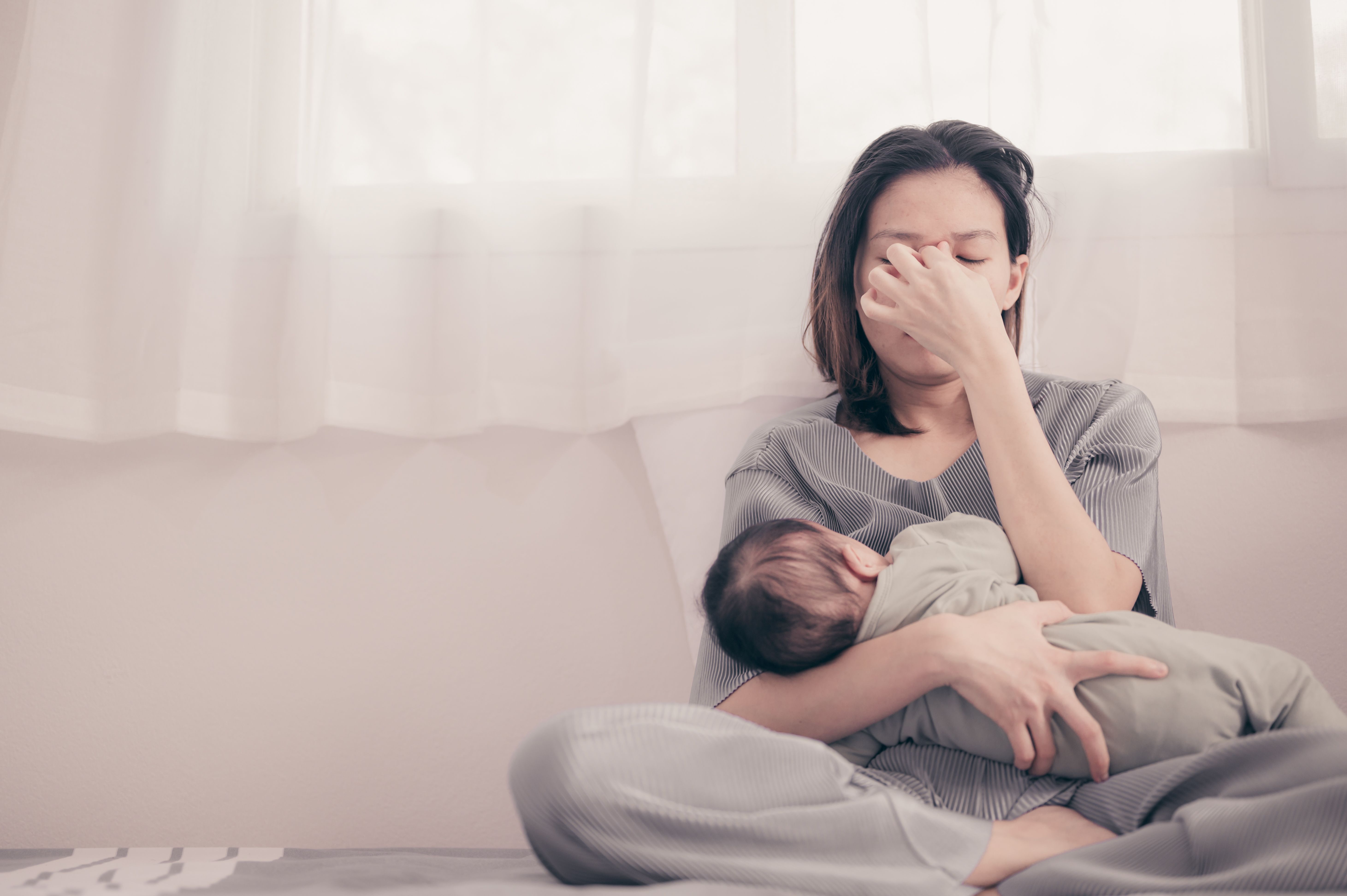 mom stressed out with baby on couch