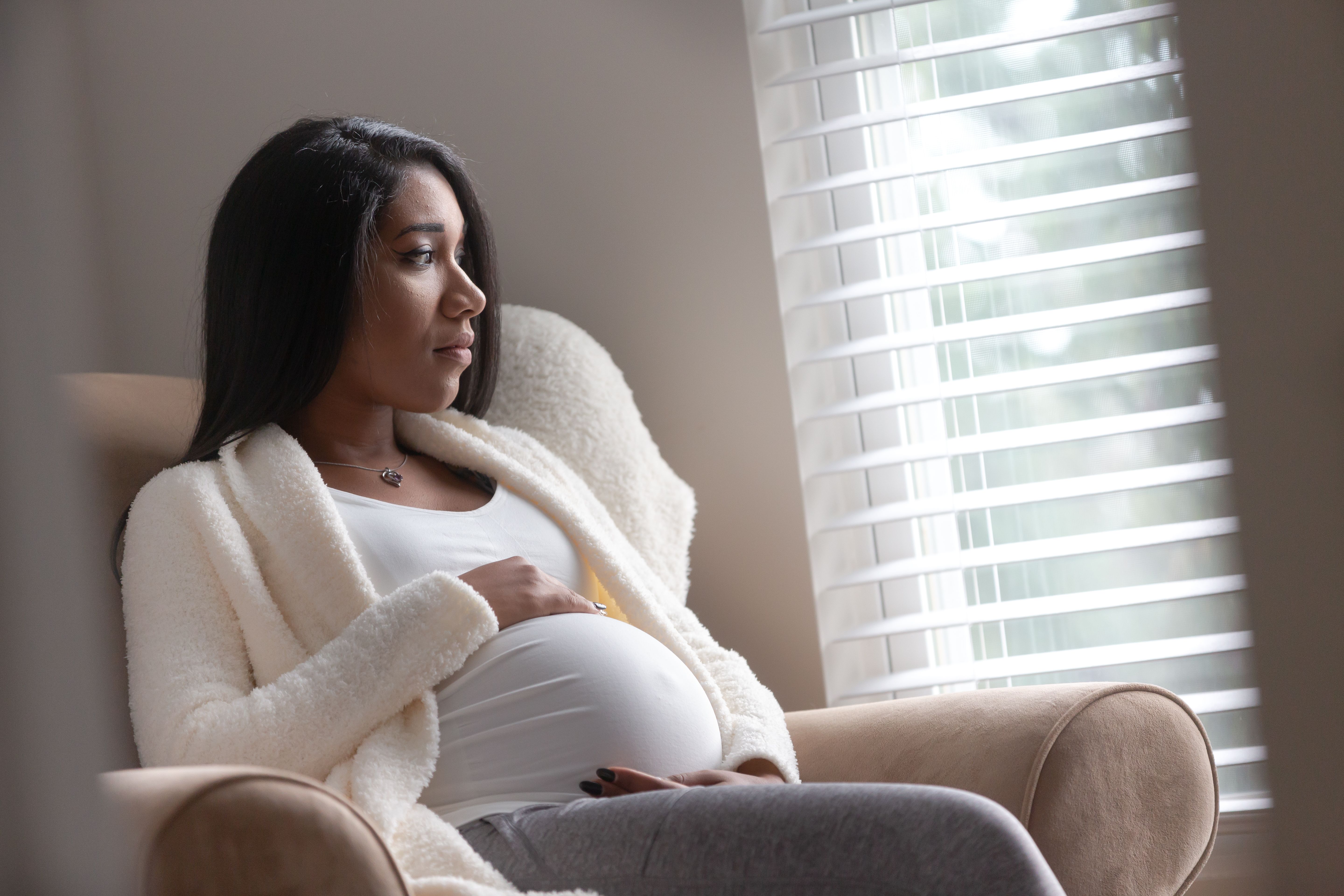 pregnant woman sitting by window