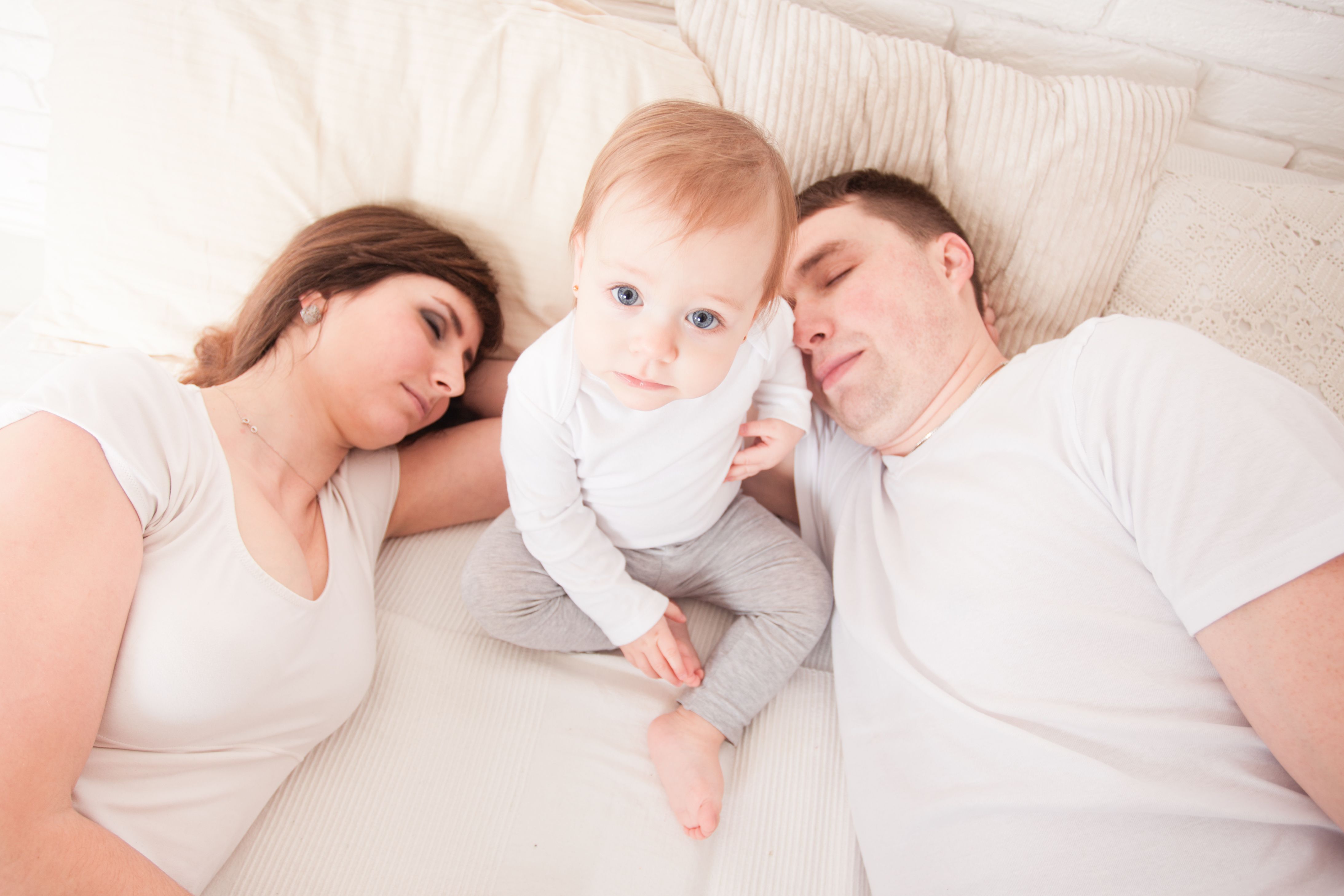parents sleeping with toddler in between awake